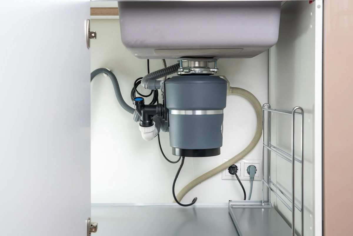 Garbage disposal and drain connections under a sink