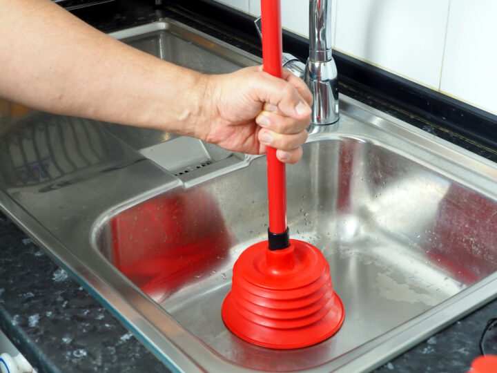 Technician unclogging a kitchen sink