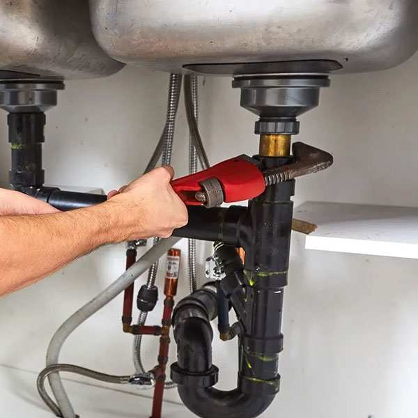 Working on the drain assembly under a kitchen sink